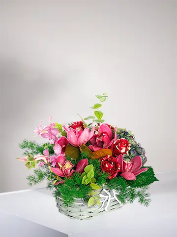 Cestino in vimini con rose rosse screziate cymbidium rosa ortensia blu